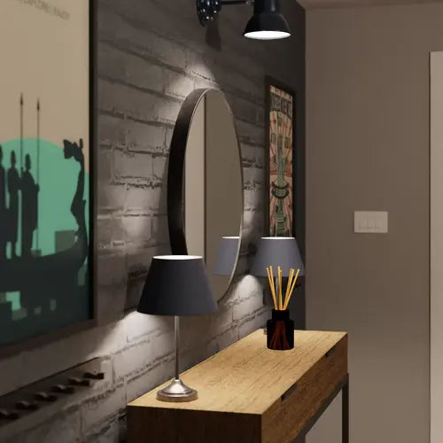 Vue latérale d'un miroir rond noir de 60 cm dans une entrée au style industriel avec une console en bois et des décorations murales