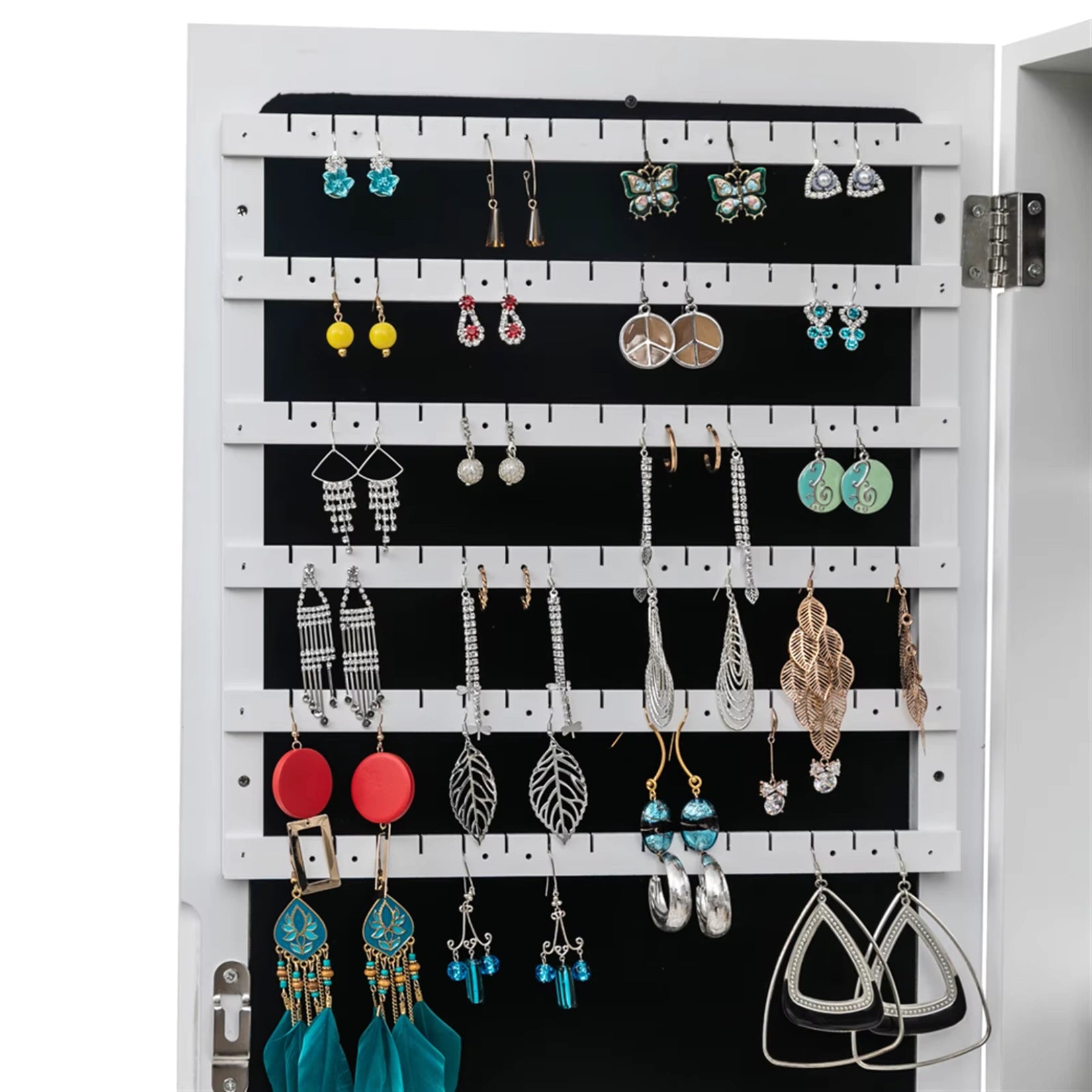 Rangement pour boucles d'oreilles et accessoires dans l'armoire à bijoux miroir sur pied.