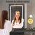 Femme utilisant l’armoire de toilette miroir LED pour son maquillage.