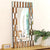 Miroir doré design rectangulaire captant la lumière naturelle sur un meuble bois clair.