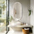 Miroir salle de bain simple vertical au design moderne, installé au-dessus d’un lavabo.